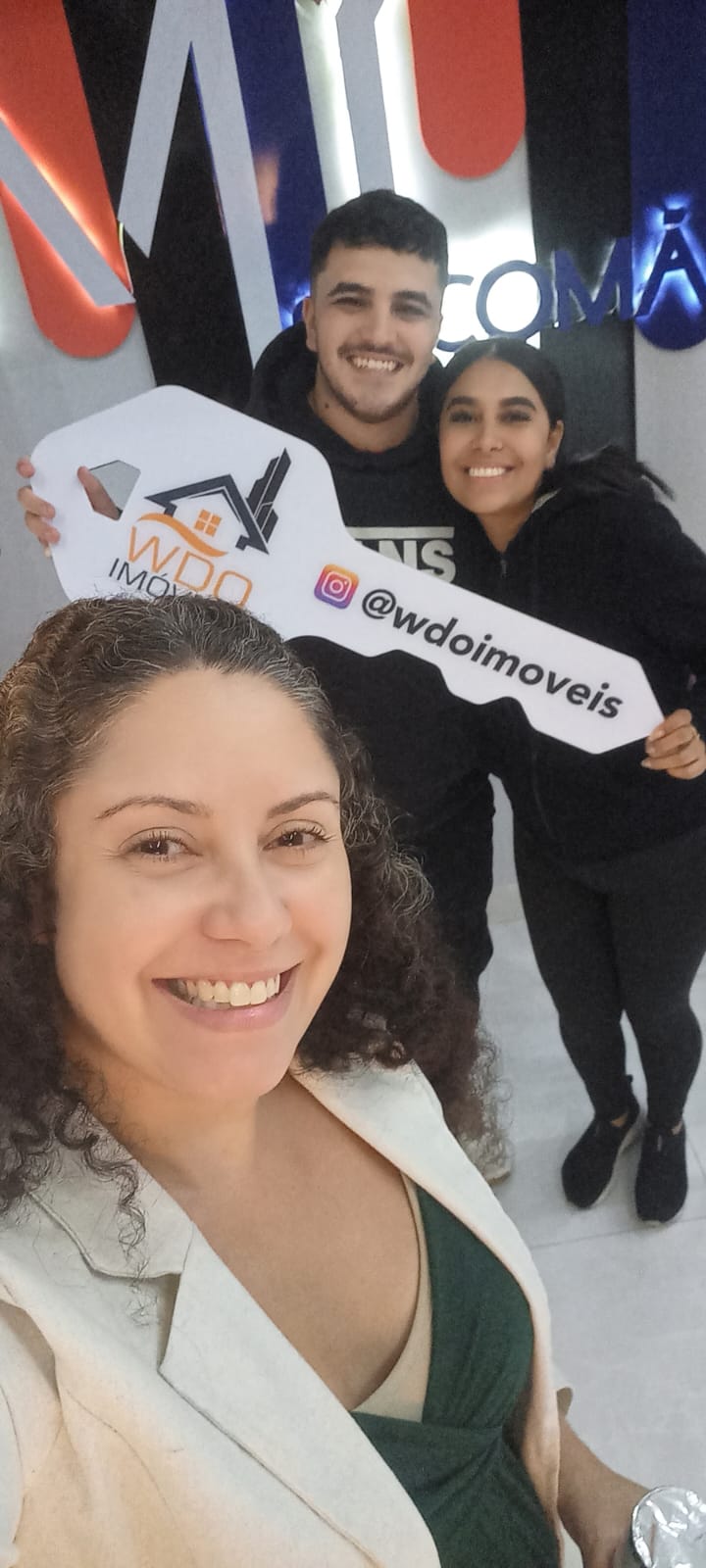 Pessoas celebrando a conquista de um imóvel com uma chave simbólica.