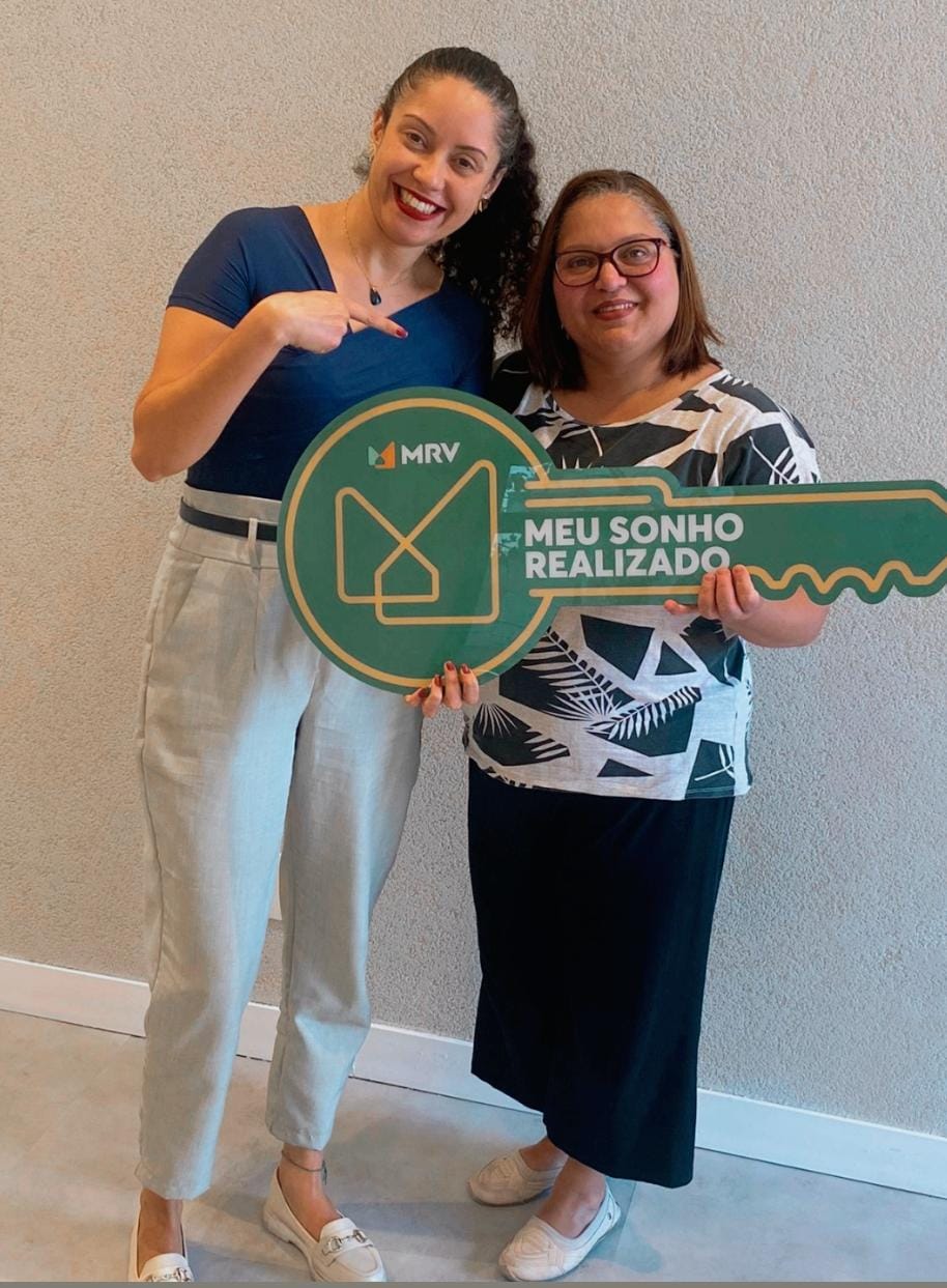 Pessoas celebrando a conquista de um imóvel com uma chave simbólica.